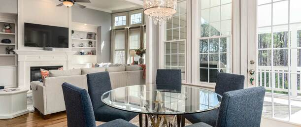 dinning table and living room setting with sliding windows and chandelier
